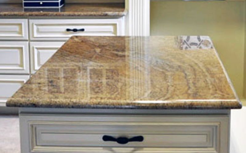 Kitchen remodel showing island featuring a large granite surface.